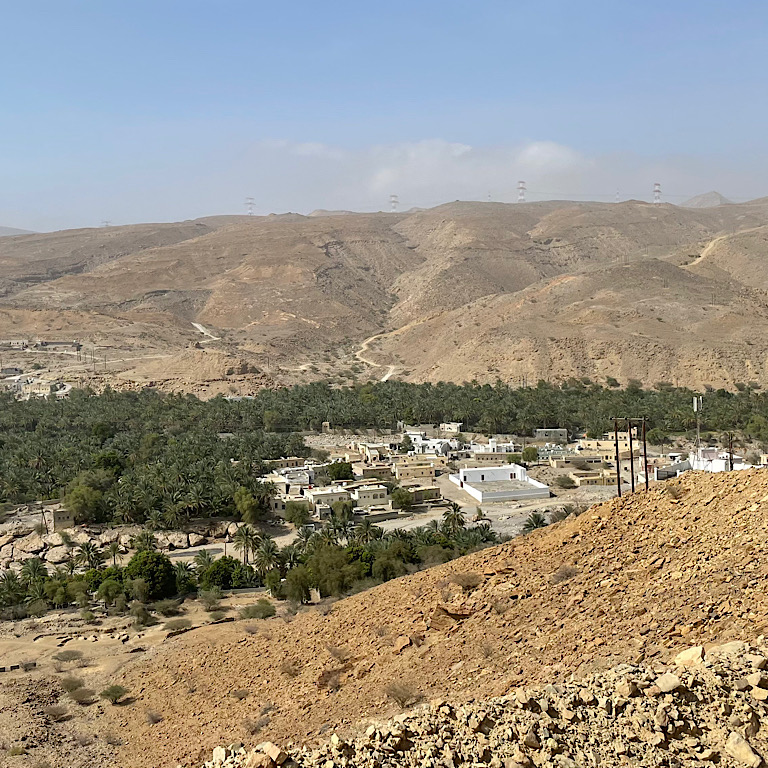 photo of looking down on a green village in a valley